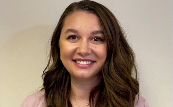 A person with long brown hair smiling Description automatically generated