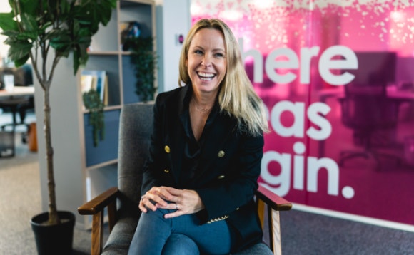 A person sitting in a chair smiling Description automatically generated